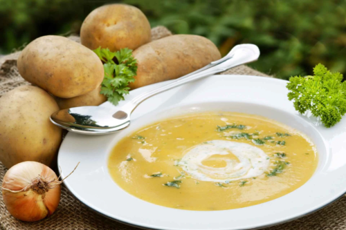 Kartoffelsuppe mit Schmand und Petersilie – serviert auf einem weissen Teller [Foto: AdobeStock_Johanna Mühlbauer]