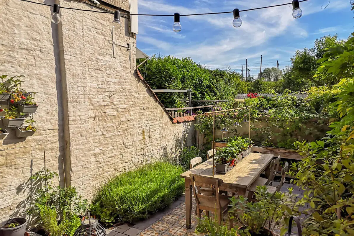 Balkonpflanzen stehen auf einer sonnigen Terrasse [Foto: AdobeStock_Luoxi]