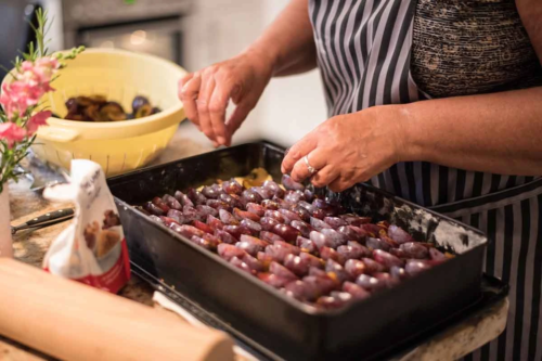 Pflaumenkuchen wird mit Pflaumen belegt [Foto: AdobeStock_Nicole]