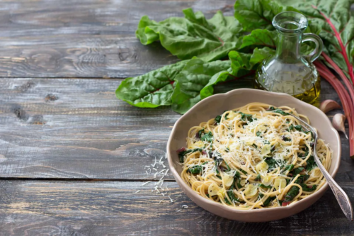 Pasta mit Mangold auf einem rustikalen Holztisch neben Mangold [Foto: AdobeStock_Olepeshkina]