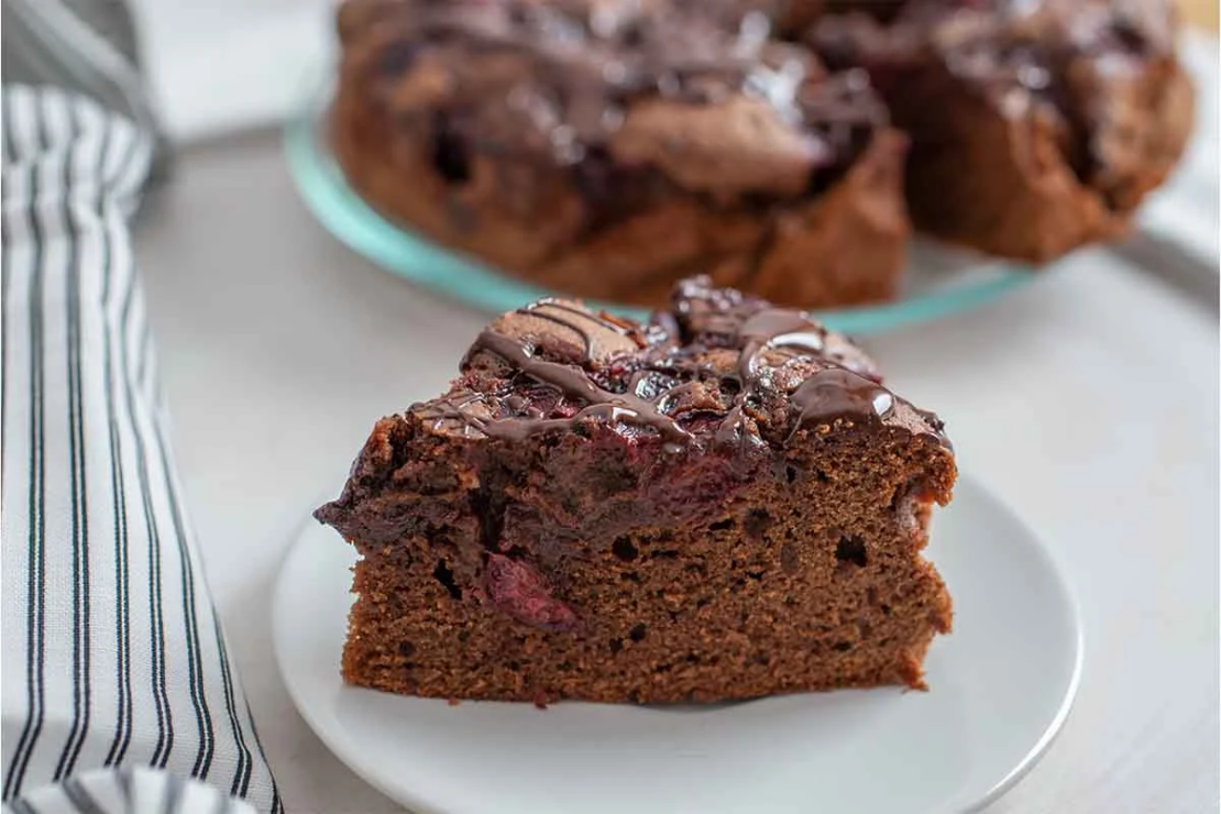 Schokoladenkuchen mit Kirschen auf einem weissen Teller [Foto: AdobeStock_A_Lein]