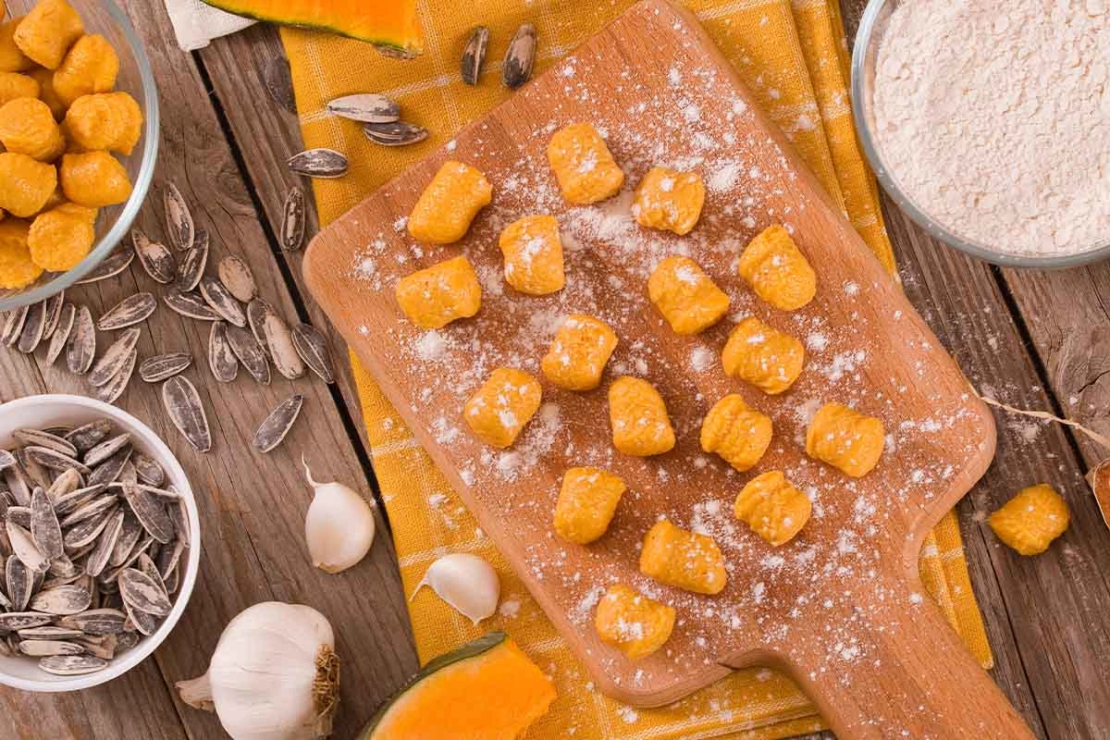 Kuerbis Gnocchi werden auf einem Holzbrettchen geformt [Foto: AdobeStock_Mi.Ti.]